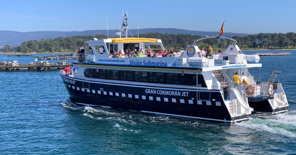 Catamarán navegando entre bateas mejilloneras en la Ría de Arousa durante la Ruta del Mejillón en O Grove