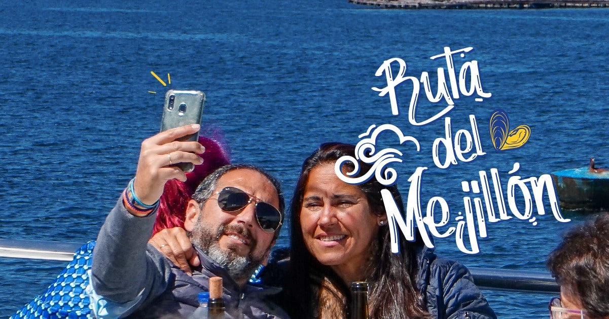 Pareja haciendose un selfie a bordo del mejor barco de mejillones en O Grove con el mar de fondo.